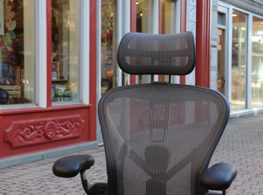 Close-up of a mesh ergonomic chair headrest showing suspension weave detail